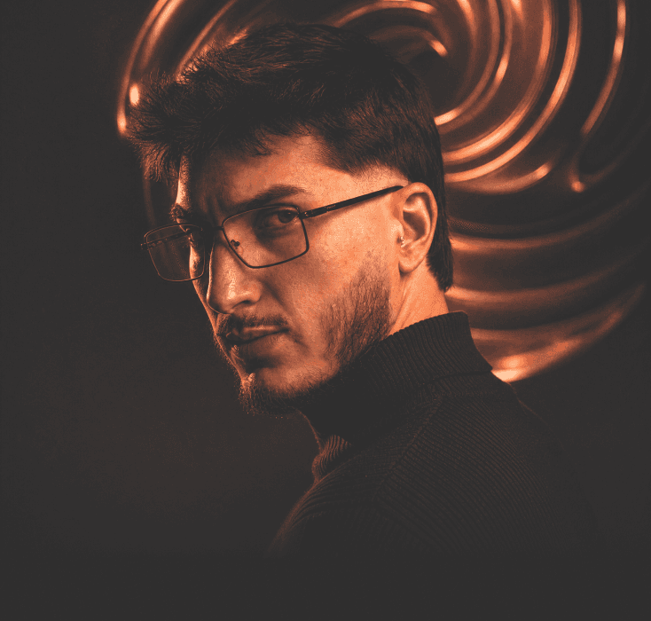 Victor Souza, fundador da Espiral Digital Studio, de perfil diante de um fundo de espirais em cobre.